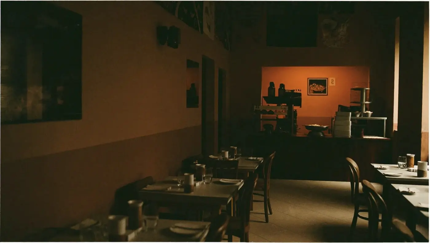 The dining room seen wide and empty, warm light over the tables.